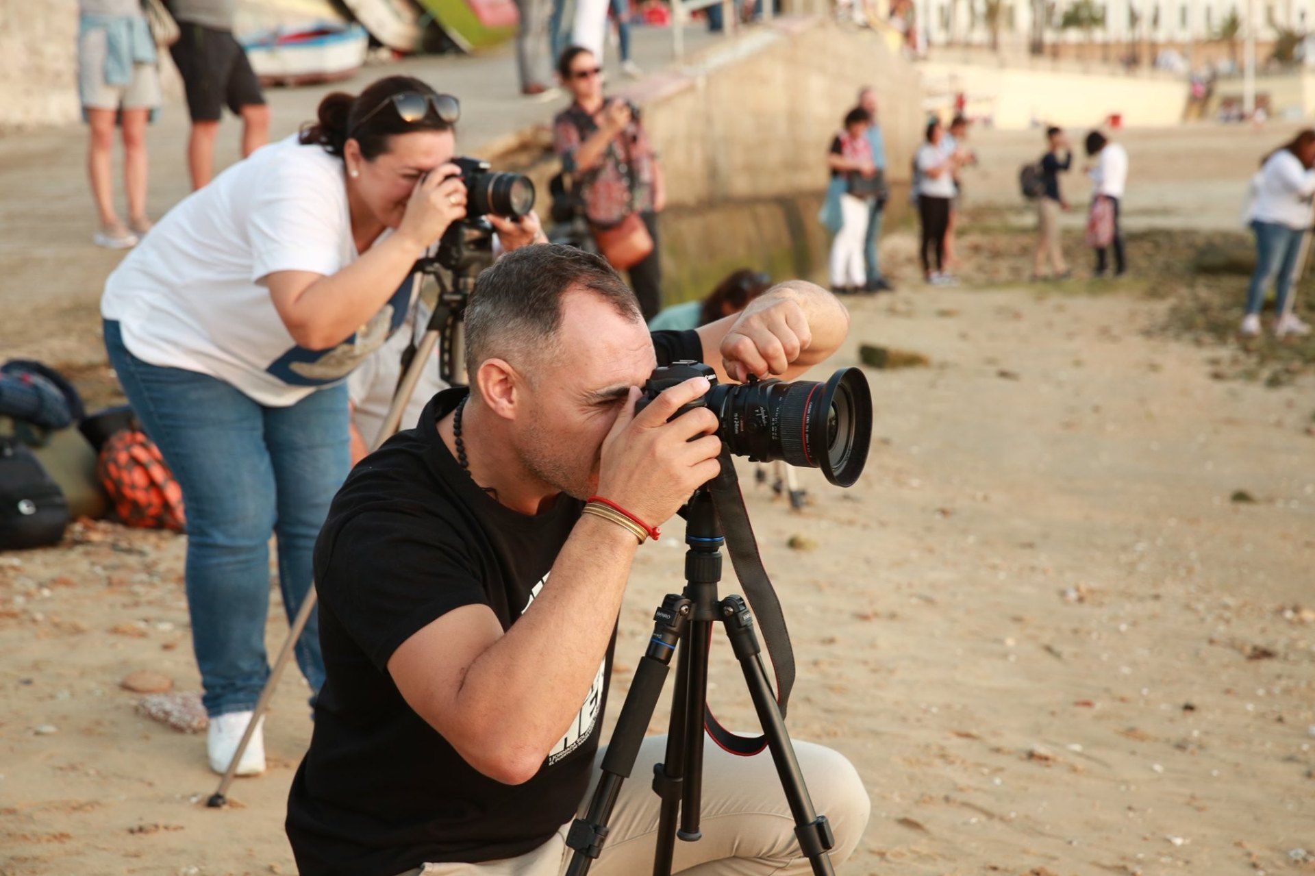 Manuel Esteves acompañando a alumnos durante una revisión de fotos en el curso